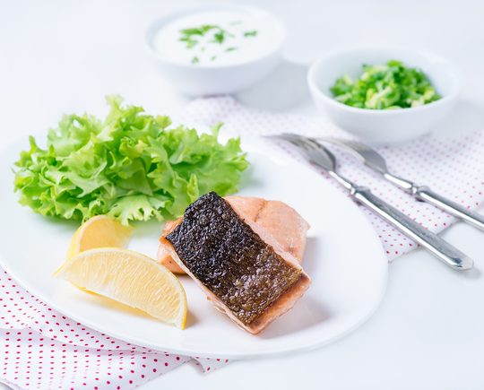 Grilled red fish fillet with lemon and green salad
