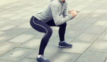 close up of woman doing squats outdoors