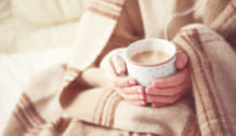 cup of hot coffee warming in the hands of a girl