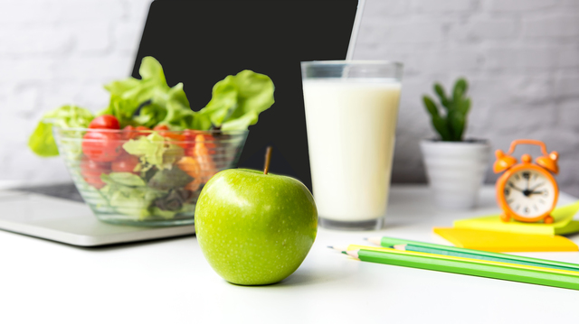 green apple with milk, salad, healthy. Laptop PC and pencils.