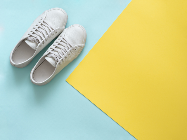 White sneakers on blue and yellow, copy space, top view